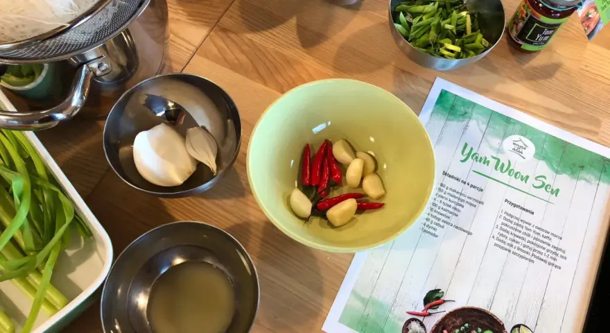 Składniki do zupy **sos tom yum**: czosnek, chili, zielona cebulka, makaron i pasta **sos tom yum** w słoiczku.