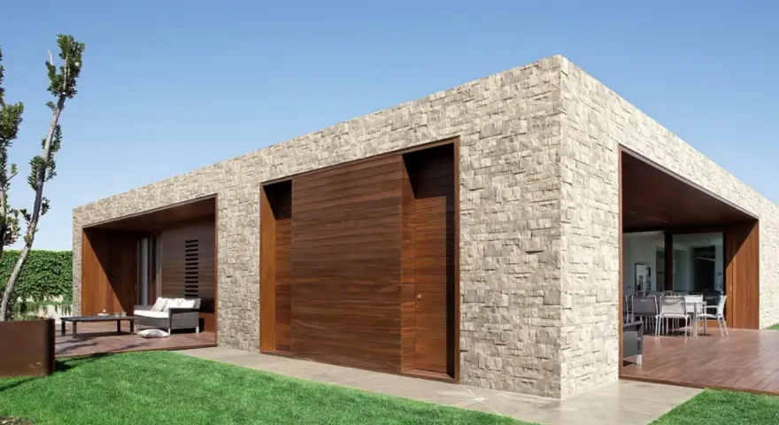 Moderna casa con facciate in pietra e inserti in legno. Un'oasi di design contemporaneo.