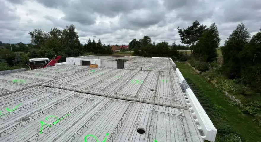 Budowa stropu monolitycznego z widocznym zbrojeniem i szalunkiem traconym.