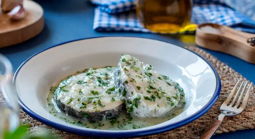 Deliciosa merluza en salsa verde, con perejil fresco picado y un toque de ajo. Un plato clásico y sabroso.
