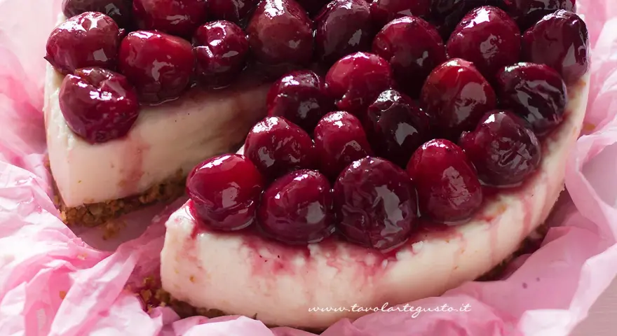 Deliziosa cheesecake alle ciliegie, con una base croccante e una crema vellutata, ricoperta da ciliegie succose e lucide.