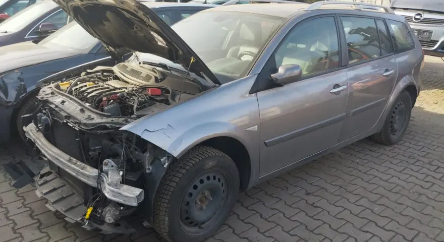 Szary kombi z otwartą maską, widoczny silnik i uszkodzony przód. Idealny, by dowiedzieć się, jak sprzedać auto na części.