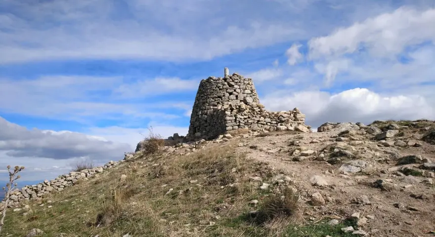 Ruinas de piedra en la cima del **cerro de San Pedro**, bajo un cielo azul con nubes blancas.