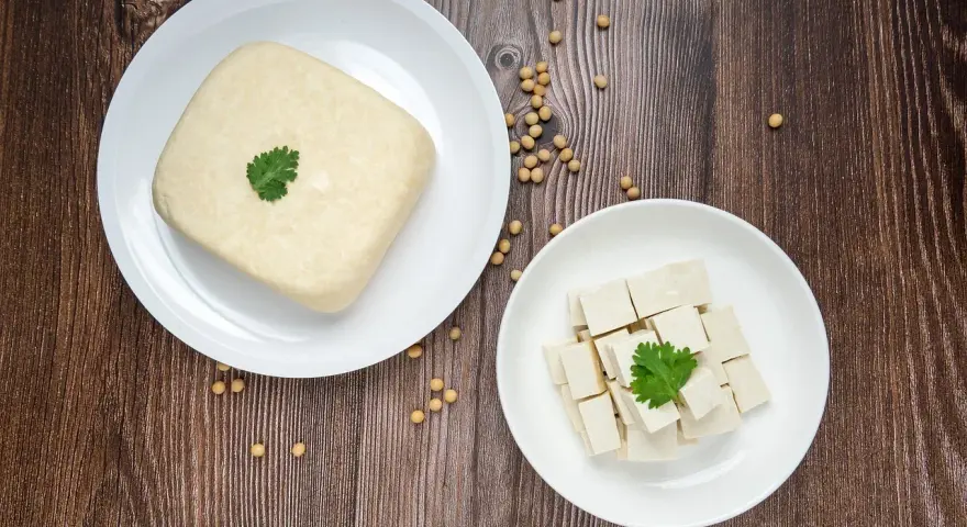 Kostka tofu i pokrojone w kostkę tofu na talerzach, gotowe do przygotowania pysznego tofu przepisu.
