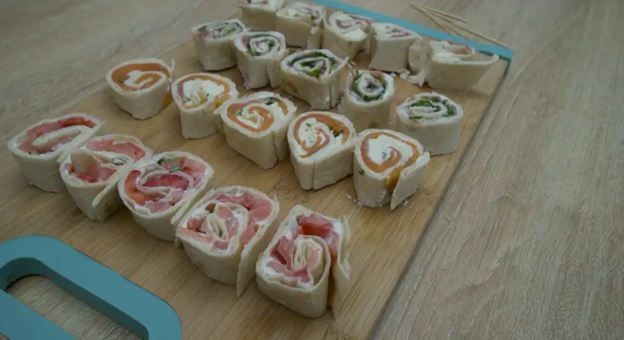 Petits roulés de wrap froid, parfaits pour un apéritif facile. Saumon, fromage frais et herbes se marient à merveille dans cette recette.