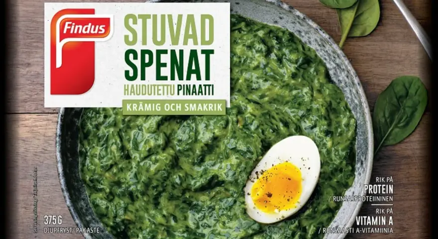 En skål med krämig stuvad spenat, toppad med ett halvt kokt ägg. Findus logotyp syns tydligt.