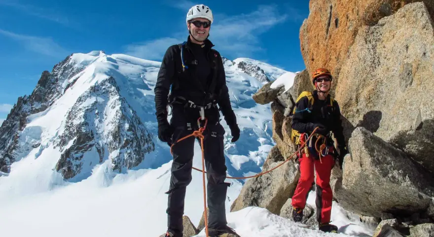 Zwei Bergsteiger auf dem Weg zur Mont Blanc Besteigung, umgeben von Schnee und Felsen.