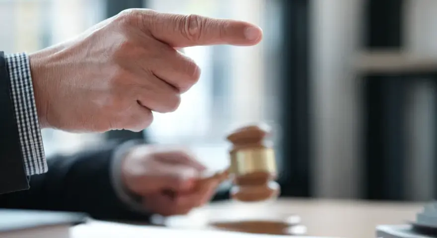Sędzia wskazuje palcem, młotek sądowy w dłoni. Sprawa dotyczy śmierci wierzyciela a dług.