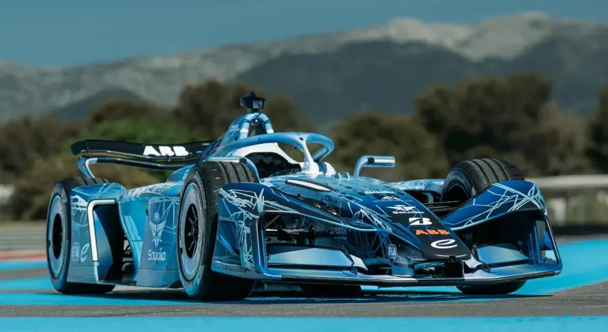 Coche de Fórmula E Gen 4 azul con diseño futurista, listo para la carrera en un día soleado.