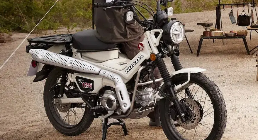 Honda CT 125 lista para la aventura. Su diseño robusto y el color blanco la hacen ideal para explorar caminos rurales o disfrutar de un día de campo.