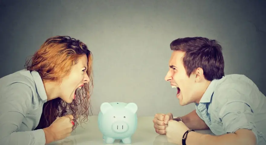 Un couple se crie dessus, poings serrés, devant une tirelire. Un vrai vol entre époux, la dispute pour l'argent est intense.