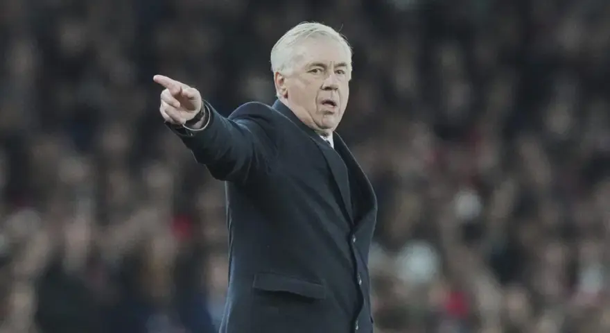 Carlo Ancelotti, con su característico gesto, señala algo en el campo.