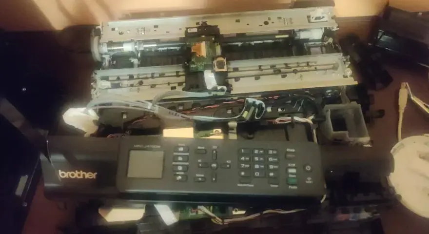 Rozłożona drukarka Brother MFC-J470DW, być może z powodu błędu 48. Widać wnętrze z taśmami i płytkami.