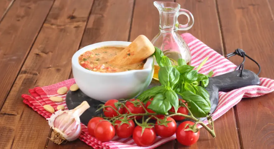 Mortai con pesto alla trapanese, pomodorini, basilico, aglio e mandorle, pronti per un sapore autentico.