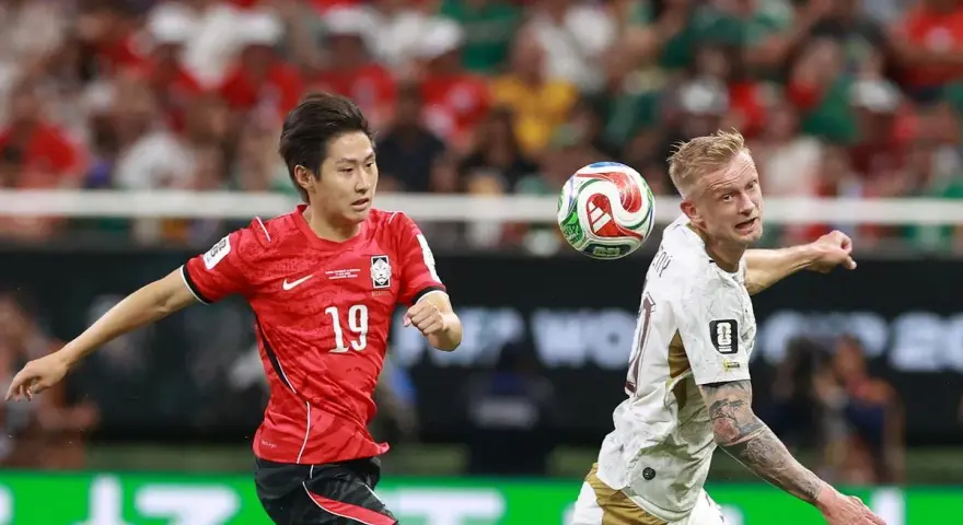 Jugador surcoreano con el número 19, Kang-in Lee, disputa un balón aéreo contra un rival.