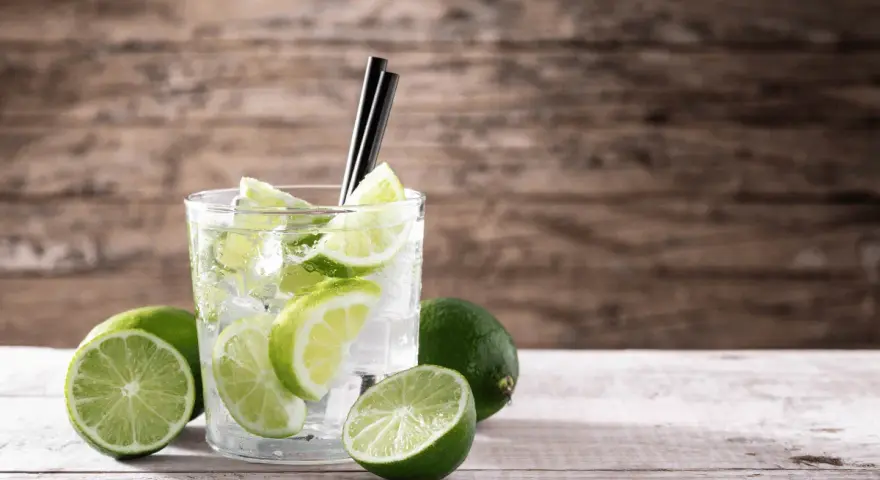 Orzeźwiający drink z limonką i lodem, ozdobiony plasterkami cytrusów. Idealny na upalne dni.