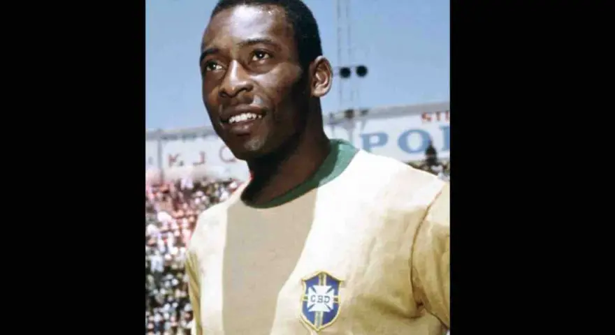 Uśmiechnięty Pelé w żółtej koszulce z herbem Brazylii. Jego niesamowite pelé statystyki mówią same za siebie.