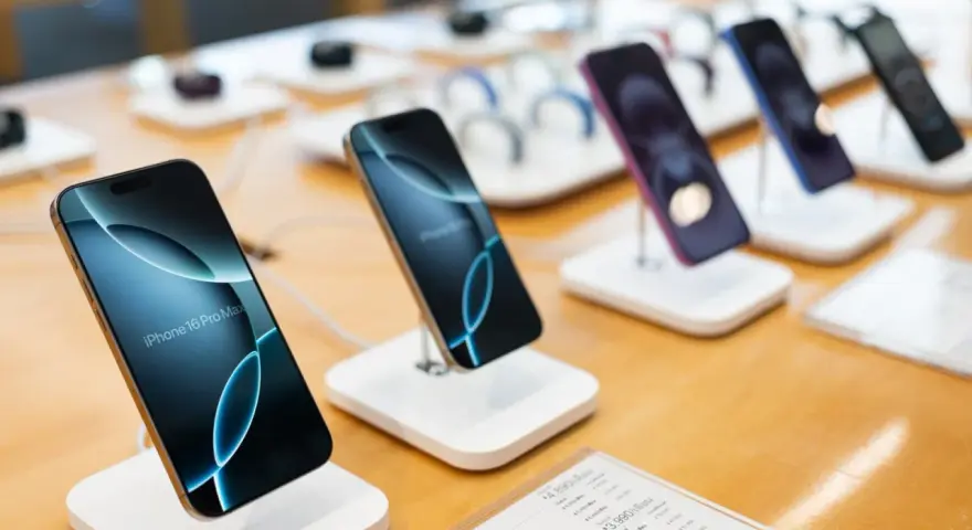 Flera iPhones visas upp på en disk, redo för den som vill byta iPhone. En iPhone 16 Pro Max syns tydligt.