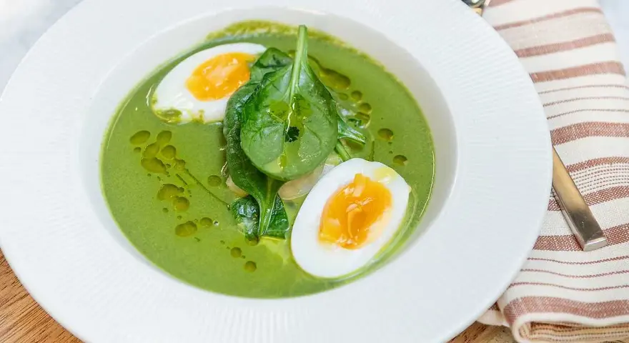 En krämig spenatsoppa med halverat kokt ägg och färsk spenat. Ett enkelt och gott spenatsoppa recept.
