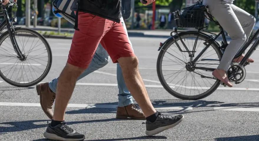 Ludzie idą i jadą na rowerze po mieście. Czy jazda na rowerze odchudza brzuch? Aktywność fizyczna pomaga spalać kalorie.
