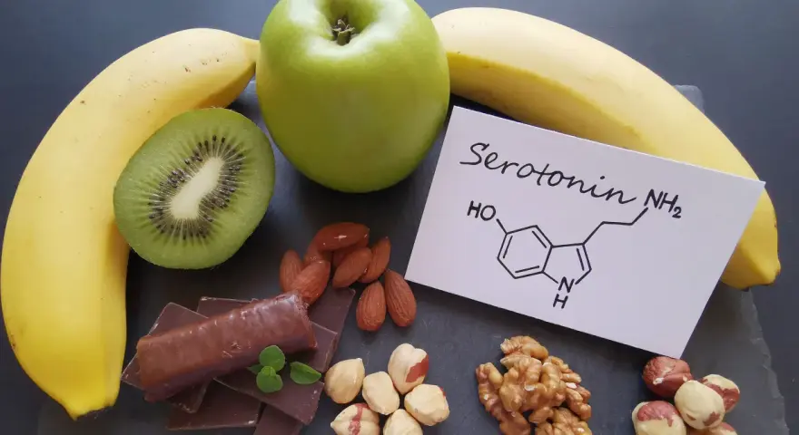 Banany, kiwi, jabłko, czekolada i orzechy. Na kartce wzór chemiczny serotoniny. W czym jest serotonina? W tych produktach!