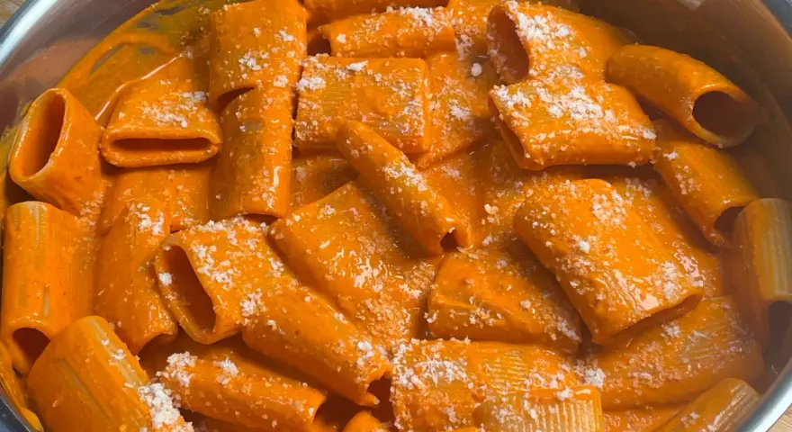 Rigatoni cremosa con un sugo rosso piccante, condita con parmigiano. Un piatto di pasta con nduja che fa venire l'acquolina in bocca.