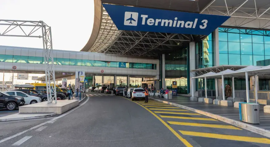 Wejście do Terminalu 3 lotniska Fiumicino z drogą dojazdową i samochodami.