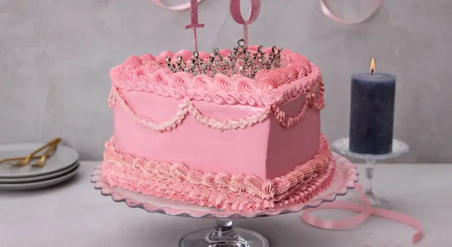 Prinzessin Torte ohne Fondant, dekoriert mit rosa Buttercreme-Rüschen und einer glitzernden Krone. Die Zahl 10 steht für den 10. Geburtstag.