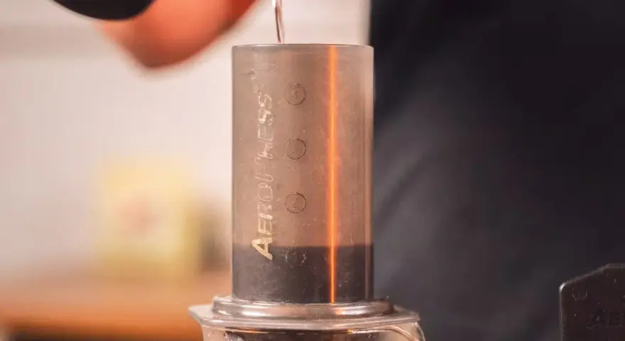 Przygotowanie kawy metodą aeropress cold brew. Woda powoli spływa do cylindra z kawą.