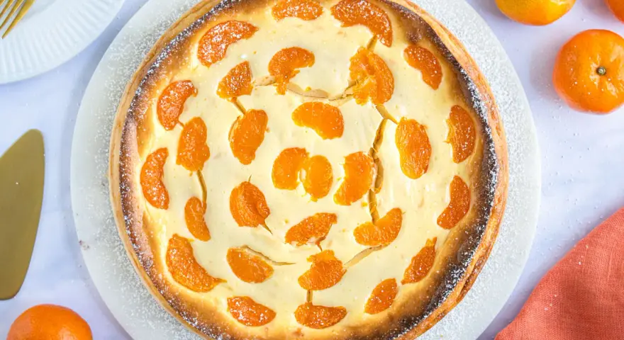 Ein goldbrauner, mit Mandarinen belegter Quarkkuchen, bestäubt mit Puderzucker. Dieser beste Mandarinen Quark Kuchen sieht köstlich aus!