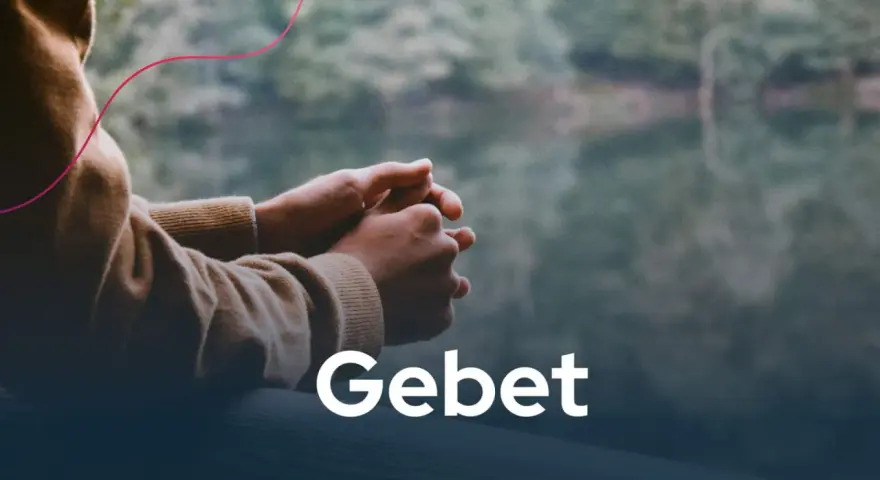 Hände im Gebet, die Ruhe und christliche Impulse in der Natur suchen. Das Wort "Gebet" steht im Vordergrund.
