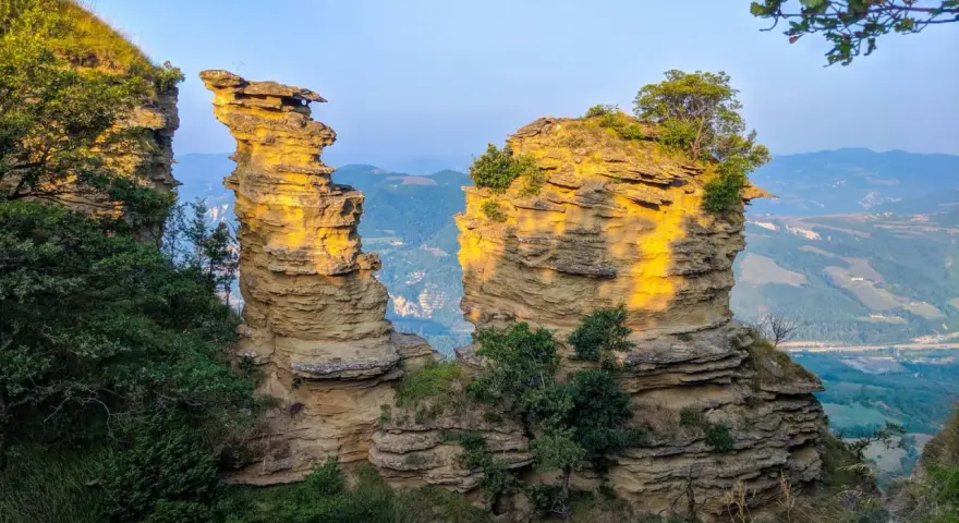 Formazioni rocciose dorate dal sole, un paesaggio mozzafiato che ricorda il cammino Bologna Firenze.