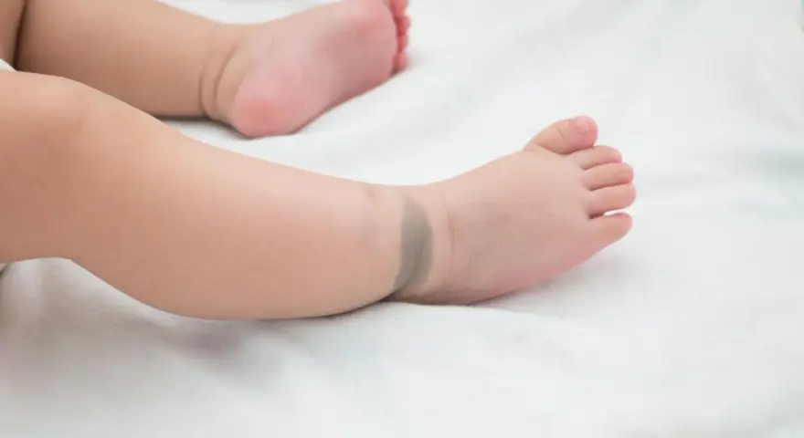 Babyfuß mit einem bläulichen mongolenfleck am Knöchel.