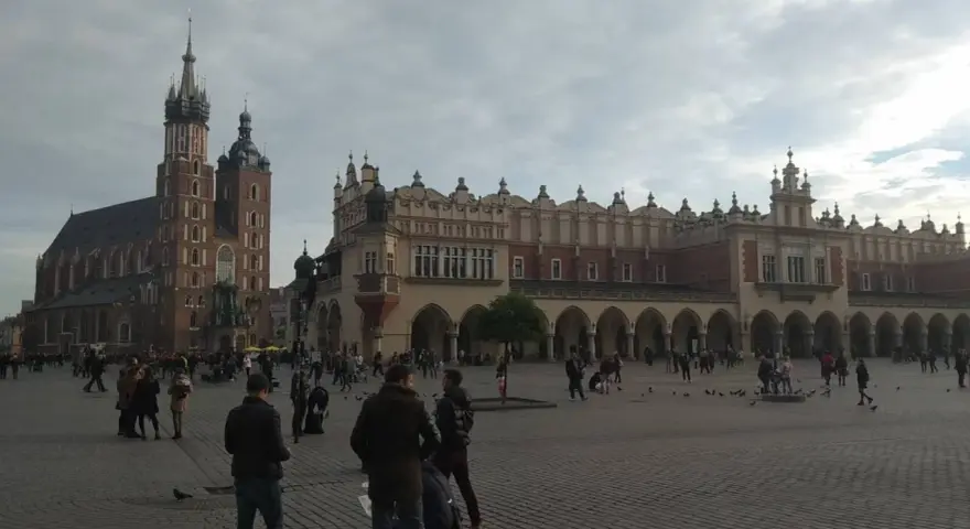 Spacer po Rynku Głównym, sercu historycznego centrum Krakowa. W tle Bazylika Mariacka i Sukiennice.