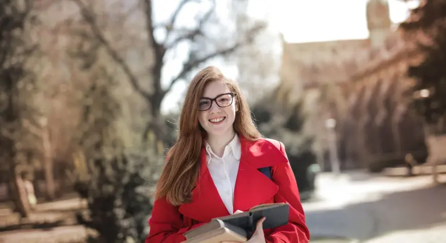 Junge Frau mit Büchern in der Hand, bereit für ihre Sprachreise. Die sprachreise kosten sind oft eine gute Investition in die Zukunft.