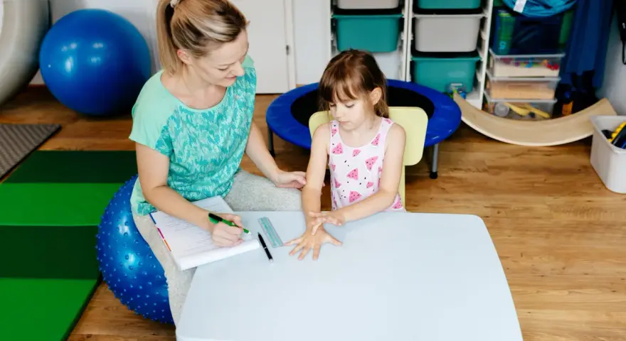Terapeuta ocenia reakcje dziecka podczas badania sensorycznego, sprawdzając jego wrażliwość dotykową i propriocepcję.