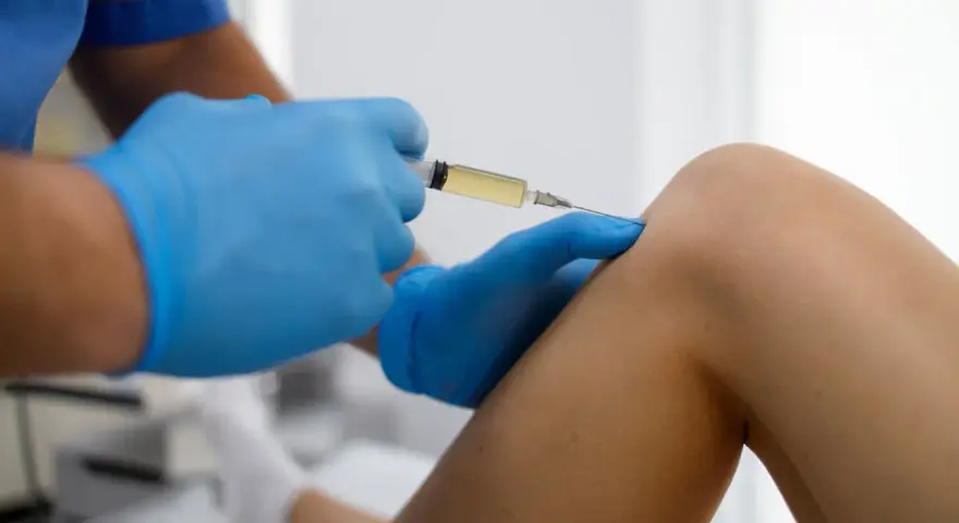 Arzt gibt Arthrose Spritze ins Knie.