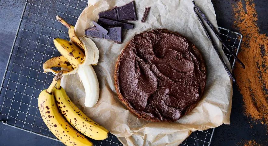 En saftig banankaka med chokladfrosting, bananer, chokladbitar och vaniljstänger.