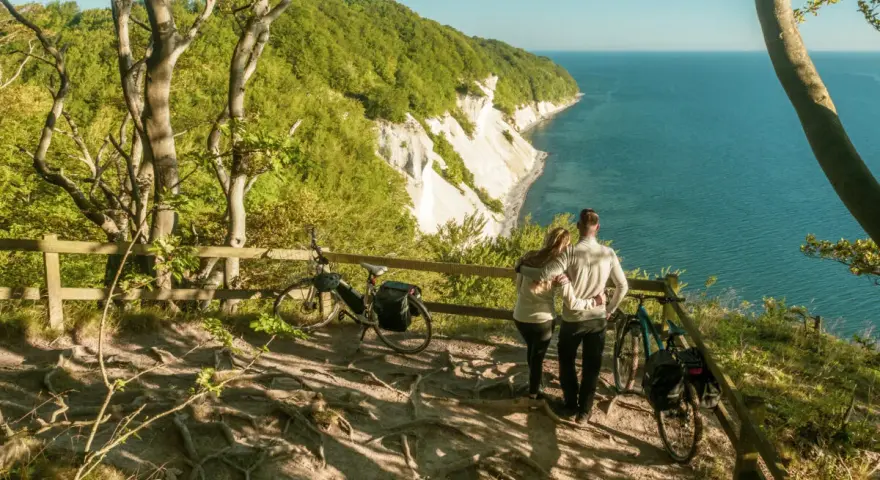 Para zakochanych podziwia widok na klify Møns Klint. Obok stoją rowery, gotowe do dalszej podróży.