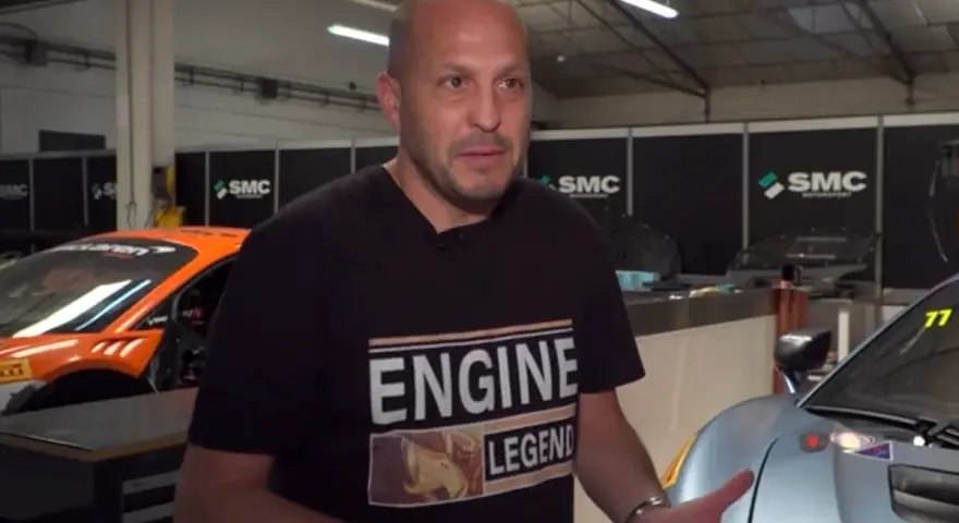 Fernando Navarrete, piloto, habla en un taller con autos de carrera.