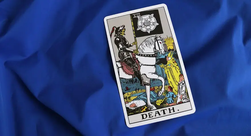 Tarot karta śmierci z rycerzem na białym koniu i flagą z różą. Symbolizuje koniec i nowy początek.