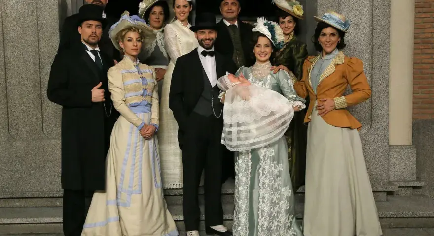 Un gruppo di persone in abiti d'epoca, con un neonato in braccio, anticipazioni una vita di famiglia e tradizione.