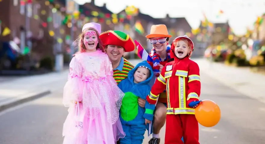 Fröhliche Familie in Kostümen feiert Fasching. Wann sind Faschingsferien in Baden-Württemberg 2026?
