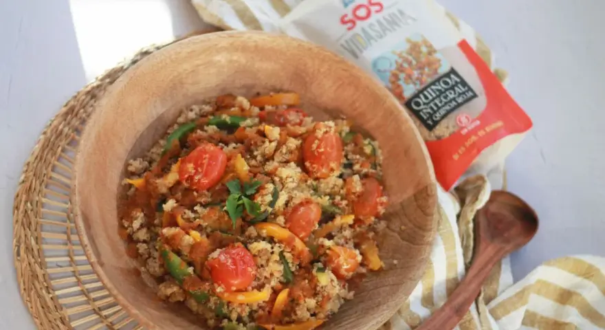 Un tazón de quinoa con verduras, tomates y pimientos. Ideal para tus recetas de quinoa.