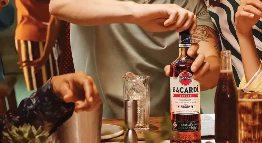 Otwieranie butelki Bacardi Spiced, rumu z naturalnymi aromatami i przyprawami, na imprezie.