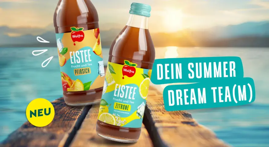 Zwei Flaschen Wolgra Eistee, Pfirsich und Zitrone, stehen auf einer Holzplanke am See. Perfekt für deinen Summer Dream Tea!