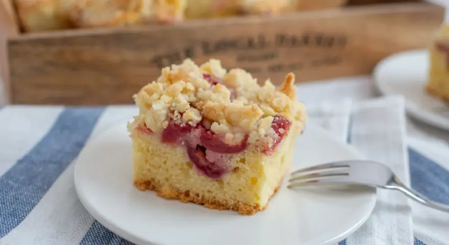 Ein Stück Kirsch-Streuselkuchen, perfekt für ein einfaches Crumble Rezept. Saftige Kirschen unter knusprigen Streuseln.