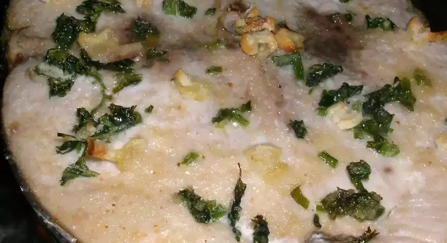 Rodaja de bonito al horno con ajo y perejil, ideal para recetas de bonito al horno.