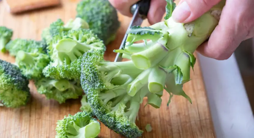 Färska broccolibuketter på en skärbräda, redo att tillagas för att bevara alla nyttiga vitaminer.