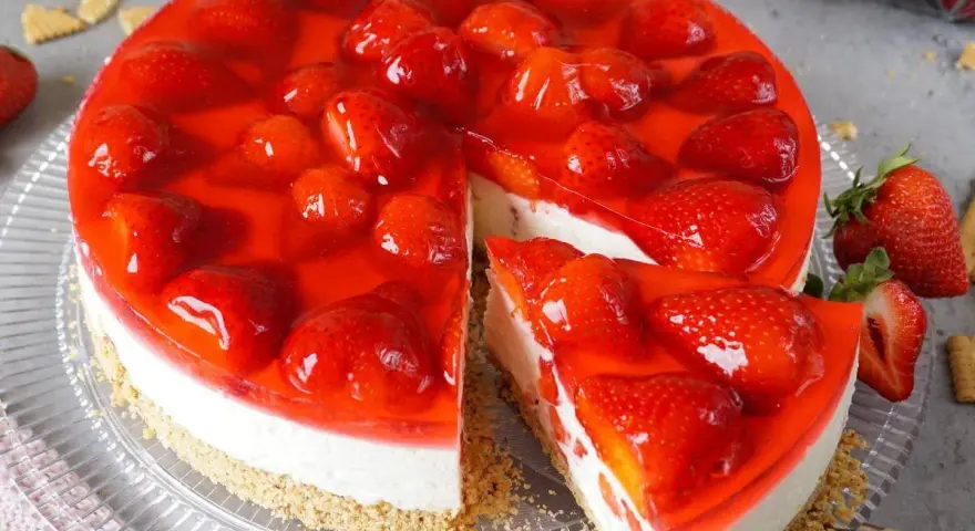 Ein saftiger erdbeerkuchen ohne backen, bedeckt mit glänzender Erdbeersoße und frischen Früchten. Ein Genuss für Augen und Gaumen!